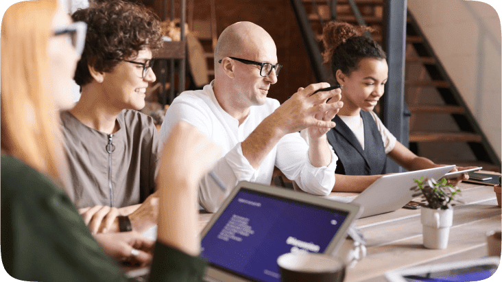 Four people at a table and discussing work