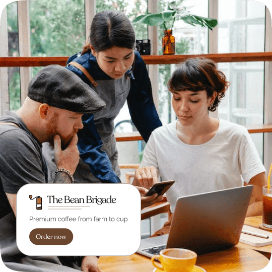 Three people at a café choosing things on a phone