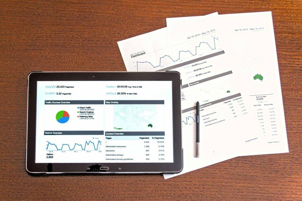 Paper, pen and tablet with graphs and data