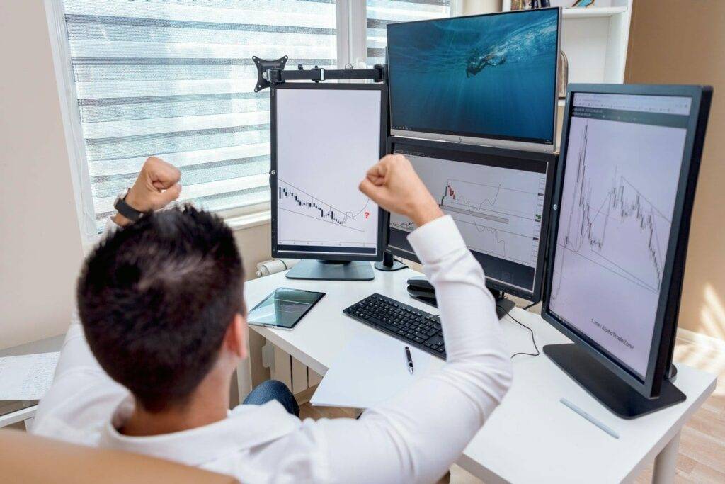 Man celebrating while looking at graphs