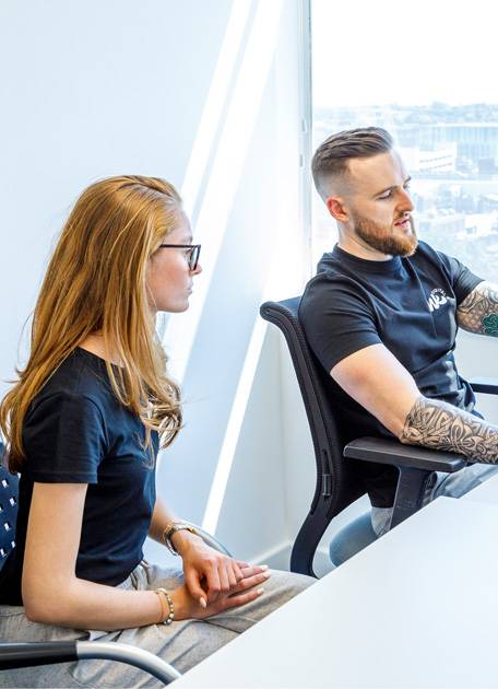 Two people sitting down and discussing at a table