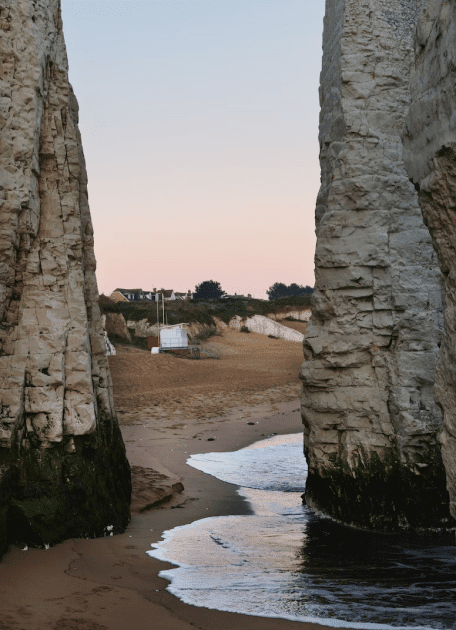 Two tall rocks with a path through the middle on a beach