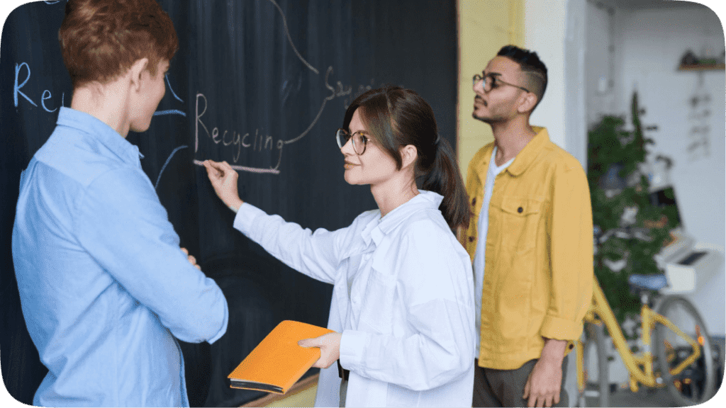 Three people discussing Recycling at a chalk board