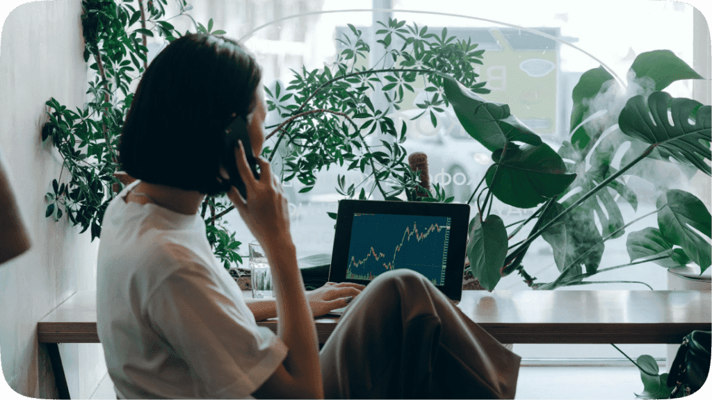 Woman sitting at a table looking at graphs on her laptop